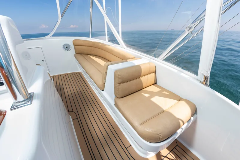 Slide: The Image of The image shows the deck of a 2004 Custom Carolina 61' Sportfisherman with beige seating. - 18