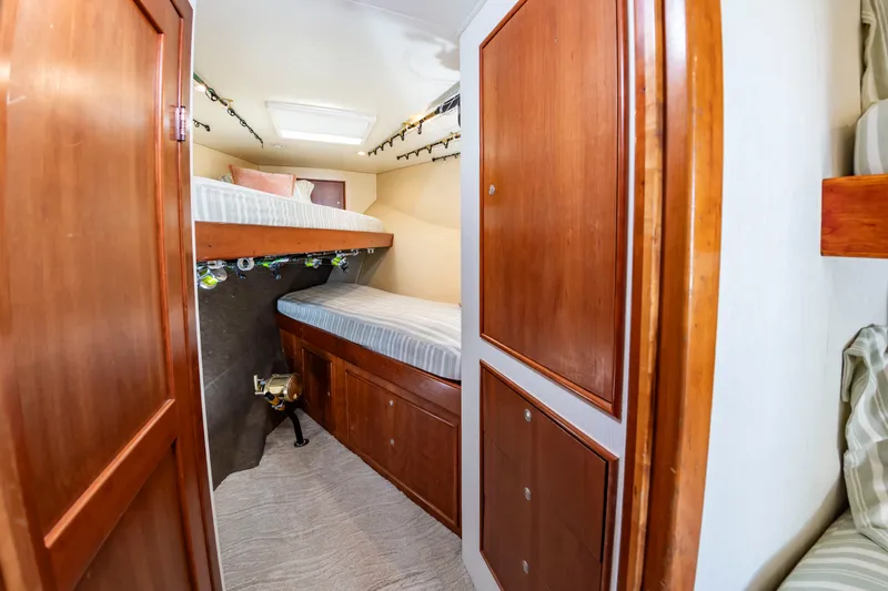 Slide: The Image of The cabin features two bunk beds with wooden cabinetry and fishing rod holders on the ceiling. - 41