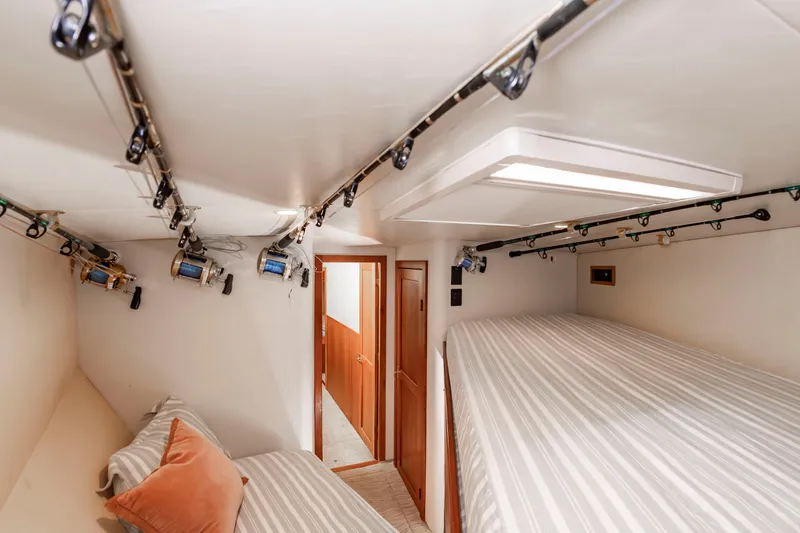 Slide: The Image of The image shows a cozy cabin with two beds and fishing rods mounted on the ceiling. - 47