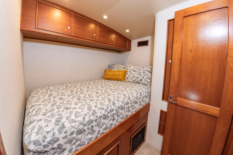 Slide: The Image of A cozy bedroom with a double bed, wooden cabinetry, and a decorative pillow. - 32