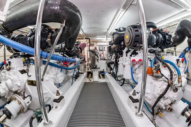 Slide: The Image of The engine room of a 2004 Custom Carolina 61' Sportfisherman features two large engines and piping. - 49
