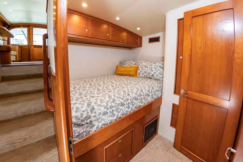Slide: The Image of The image shows a cozy cabin with a double bed, wooden furniture, and a decorative pillow. - 31