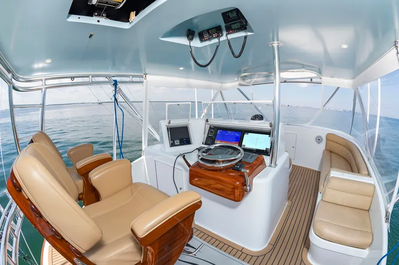 Slide: The Image of The image shows the cockpit of a 2004 Custom Carolina 61' Sportfisherman with leather seats and modern electronics. - 15