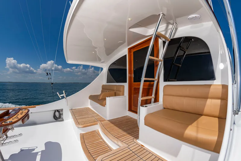 Slide: The Image of The image shows the deck of a 2004 Custom Carolina 61' Sportfisherman with beige seating. - 11