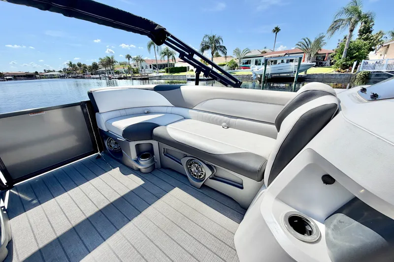Slide: The Image of 2023 Avalon 2385 LSZ pontoon boat interior with plush seating and scenic waterfront view. - 20