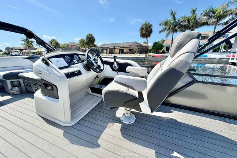 Slide: The Image of 2023 Avalon 2385 LSZ boat interior with captain's chair and control panel. - 13