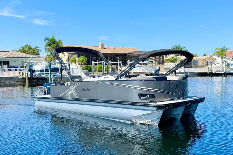 The Image of 2023 Avalon 2385 LSZ pontoon boat on a sunny waterfront, featuring sleek design and modern amenities. - 0