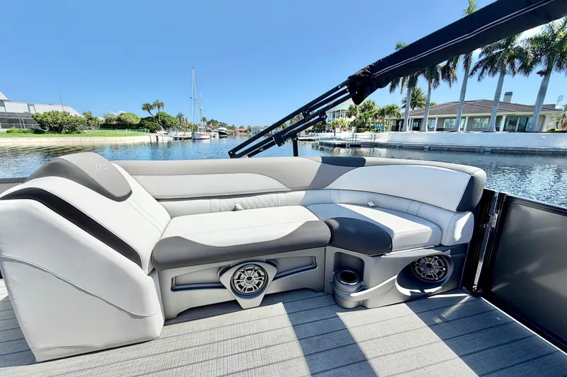 Slide: The Image of 2023 Avalon 2385 LSZ pontoon boat interior with plush seating by waterfront. - 19