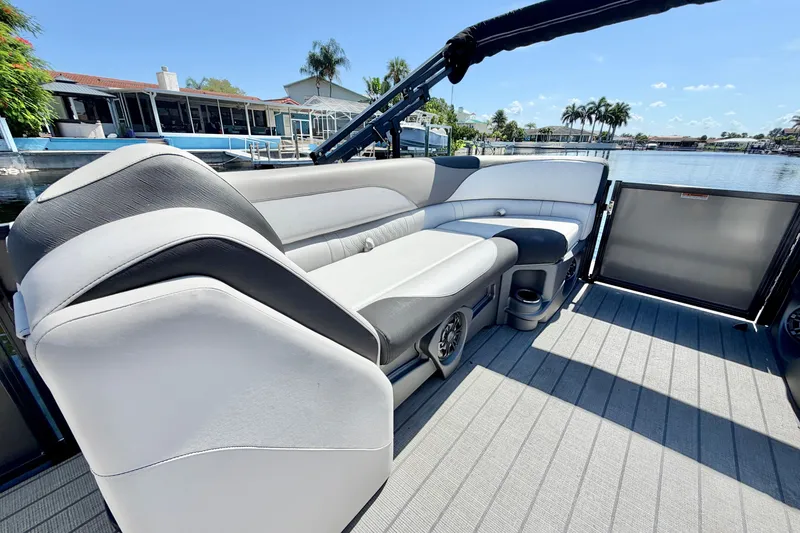 Slide: The Image of 2023 Avalon 2385 LSZ pontoon boat with luxurious seating, docked by a scenic waterfront. - 18