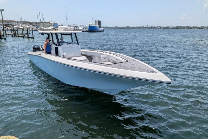 Slide: The Image of 2023 Fountain Bluewater 38 Tournament Edition boat on calm water near a marina. - 3