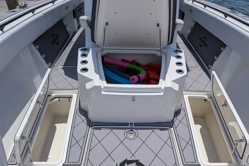 Slide: The Image of 2023 Fountain Bluewater 38 Tournament Edition boat deck with open storage compartments. - 8
