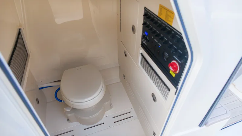 Slide: The Image of The image shows the interior of a boat bathroom with a toilet and control panel. - 21