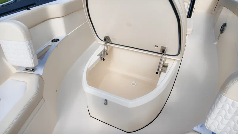 Slide: The Image of An open storage compartment on a Scout 240 XSF boat, surrounded by cushioned seating. - 20
