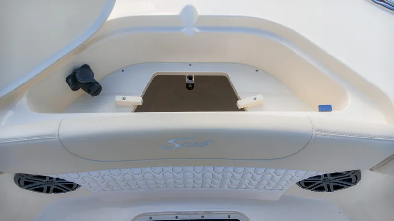 Slide: The Image of Close-up of a seating area on a Scout 240 XSF boat, featuring speakers and storage space. - 18