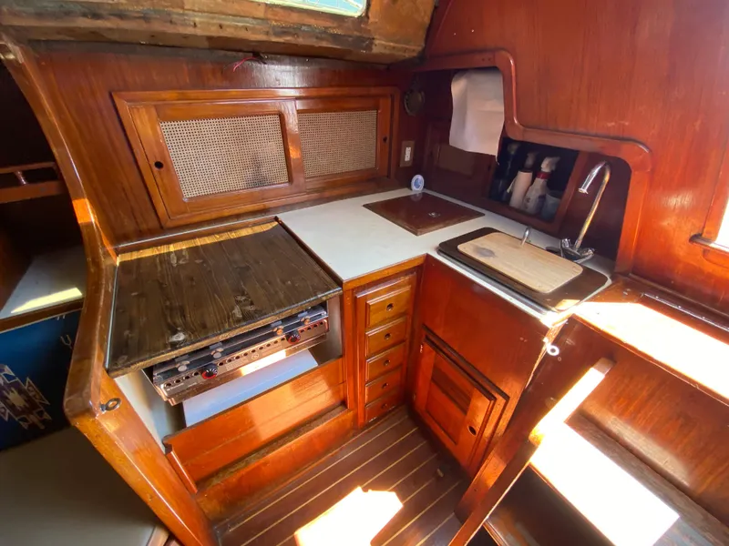 Slide: The Image of 1978 Sailboat MSY 38 galley with wooden cabinetry, stove, sink, and ample storage. - 18