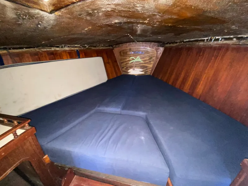 Slide: The Image of Interior cabin of 1978 Sailboat MSY 38 with blue cushions and wooden paneling. - 26