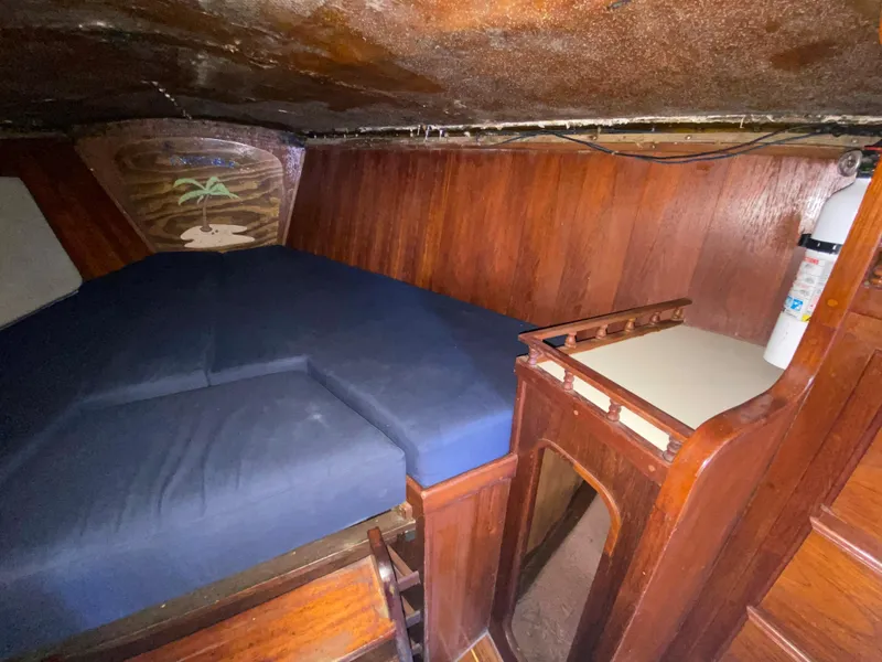 Slide: The Image of 1978 Sailboat MSY 38 interior cabin with wooden walls and blue mattress. - 27