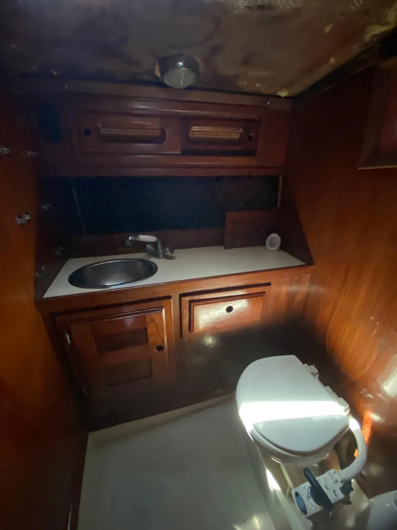 Slide: The Image of 1978 Sailboat MSY 38 bathroom with wooden cabinetry, sink, and marine toilet. - 30