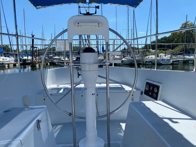 Slide: The Image of 1978 Sailboat MSY 38 cockpit with steering wheel, docked at marina. - 13