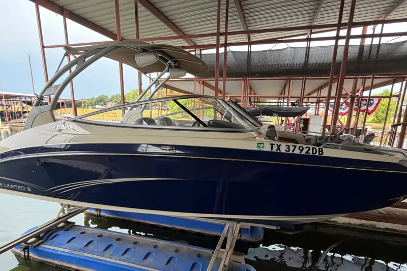Slide: The Image of 2015 Yamaha Boats 242 Limited S in dock, side view, blue and white design. - 1