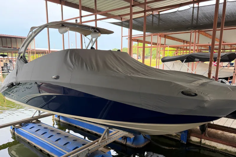 Slide: The Image of 2015 Yamaha Boats 242 Limited S covered and docked in a marina. - 7