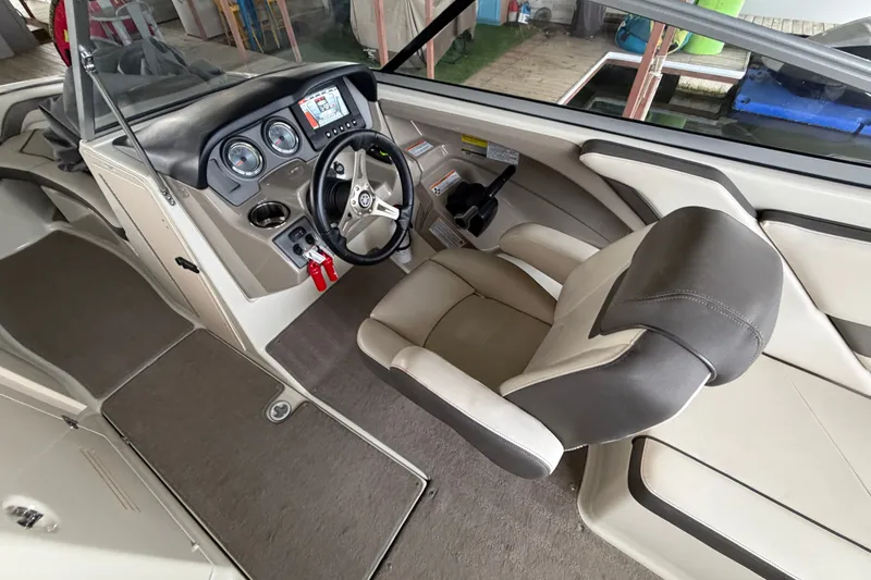 Slide: The Image of Interior of 2015 Yamaha Boats 242 Limited S, featuring steering wheel and dashboard controls. - 16