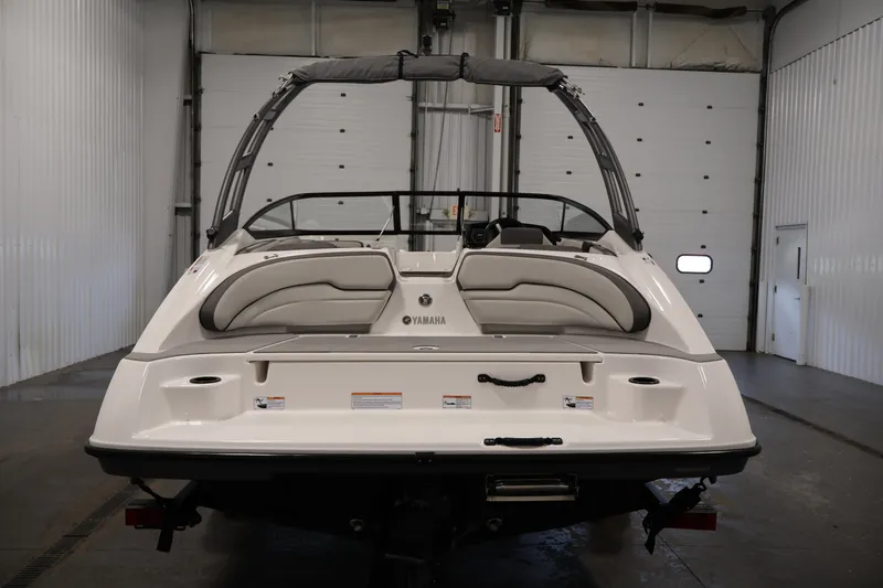 Slide: The Image of 2021 Yamaha Boats AR190 in a garage, rear view showcasing seating and design. - 6