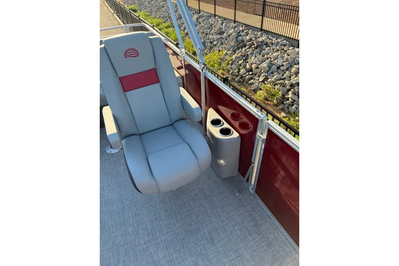 Slide: The Image of 2027 Sun Tracker Party Barge 22 RF DLX boat seat with cup holders, red and gray design. - 16