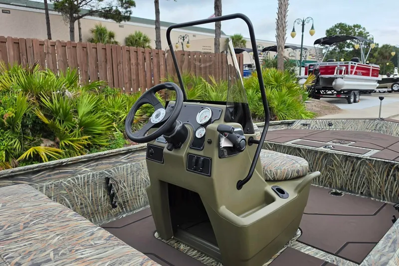Slide: The Image of 2027 Tracker Grizzly 1860 CC boat interior with steering console and camouflage seating. - 13