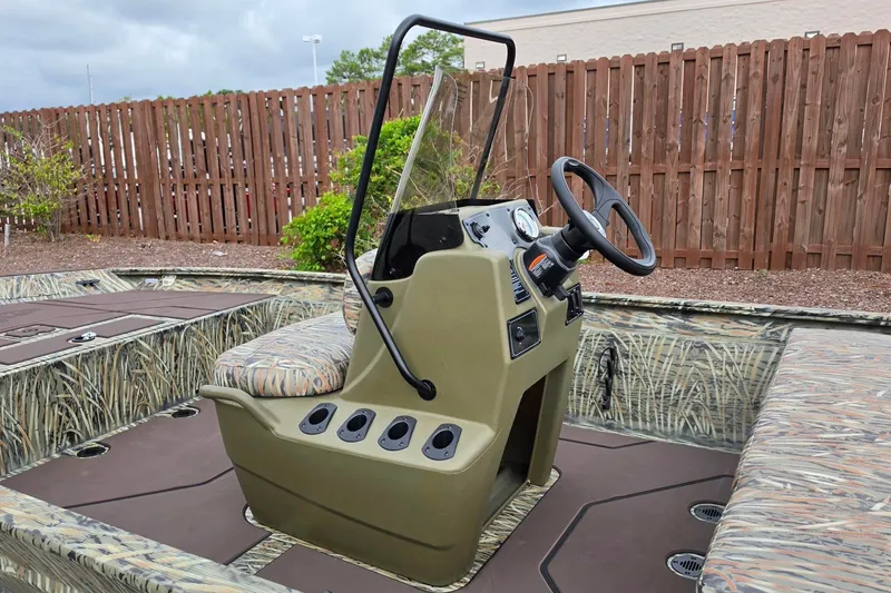 Slide: The Image of 2027 Tracker Grizzly 1860 CC boat interior with camouflage design and steering console. - 16