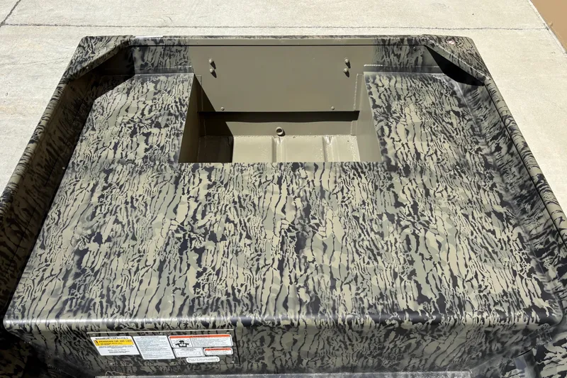 Slide: The Image of 2027 Tracker Grizzly 15 Jon boat with camouflage pattern on concrete surface. - 14