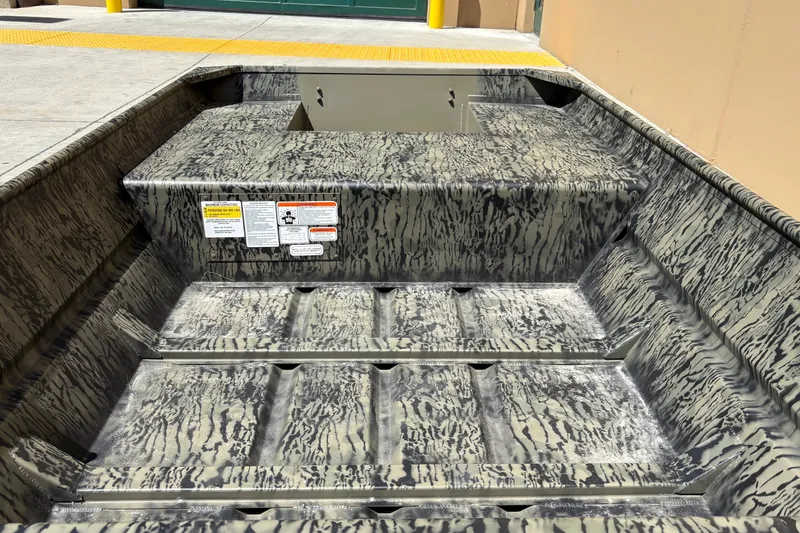Slide: The Image of 2027 Tracker Grizzly 15 Jon boat interior with camouflage pattern and safety labels. - 13