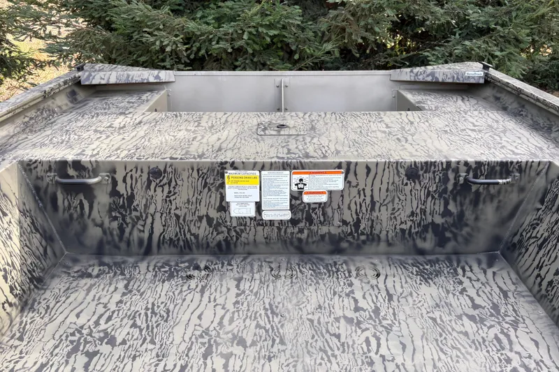 Slide: The Image of 2027 Tracker Grizzly 1754 Utility boat interior with camouflage pattern and safety labels. - 14