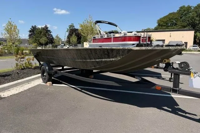 The Image of 2027 Tracker Grizzly 1754 Utility boat on trailer in parking lot, sunny day. - 0