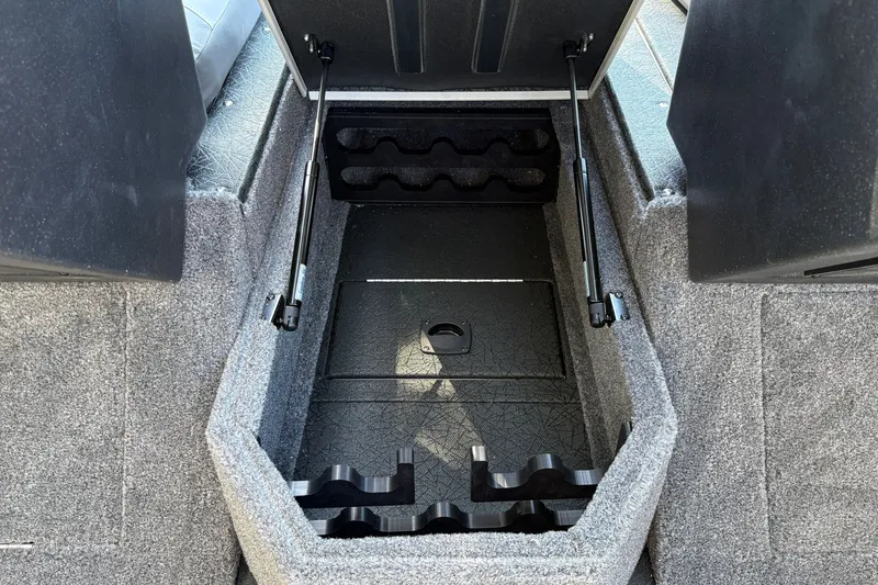 Slide: The Image of 2027 Tracker Targa V-19 Combo boat storage compartment with carpeted interior and hydraulic lifts. - 21