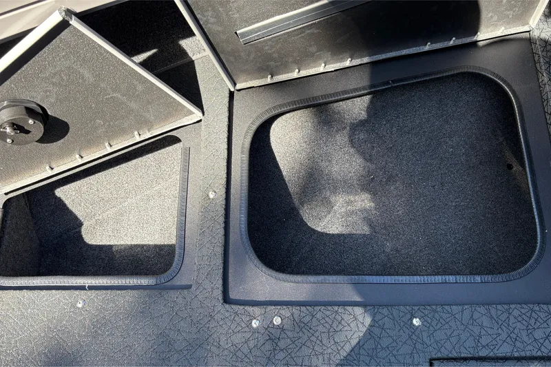 Slide: The Image of 2027 Tracker Targa V-19 Combo boat storage compartments, open and carpeted. - 28