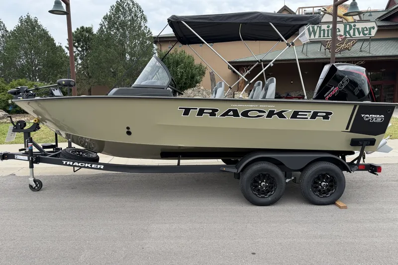 The Image of 2027 Tracker Targa V-19 Combo boat on trailer, parked outdoors near a shop. - 0