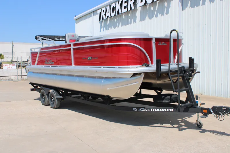 Slide: The Image of 2027 Sun Tracker Party Barge 22 RF DLX pontoon boat on trailer, red exterior. - 12