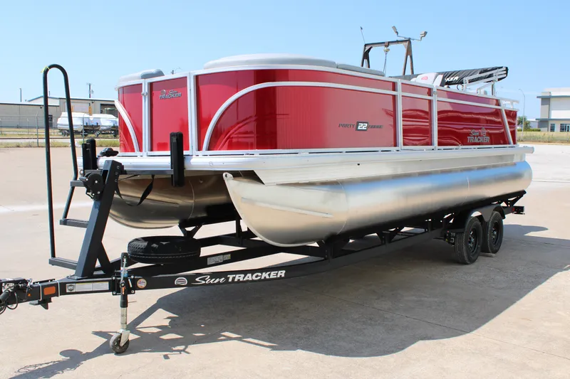 Slide: The Image of 2027 Sun Tracker Party Barge 22 RF DLX pontoon boat on trailer, red exterior. - 14