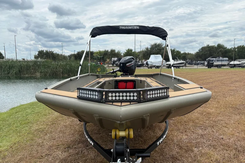 The Image of 2027 Tracker Grizzly 1756 T Marsh boat on trailer by a lake. - 1