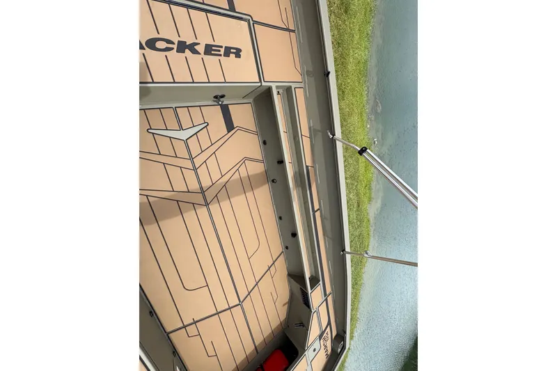 Slide: The Image of 2027 Tracker Grizzly 1756 T Marsh boat interior with sleek design near water. - 14