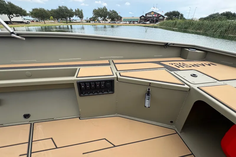 Slide: The Image of Interior view of 2027 Tracker Grizzly 1756 T Marsh boat near a lake. - 20