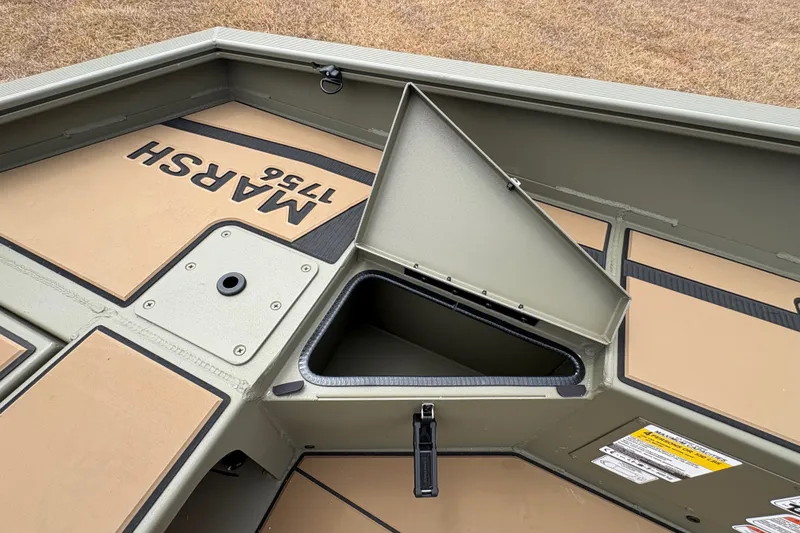 Slide: The Image of 2027 Tracker Grizzly 1756 T Marsh boat interior with storage compartment open. - 17