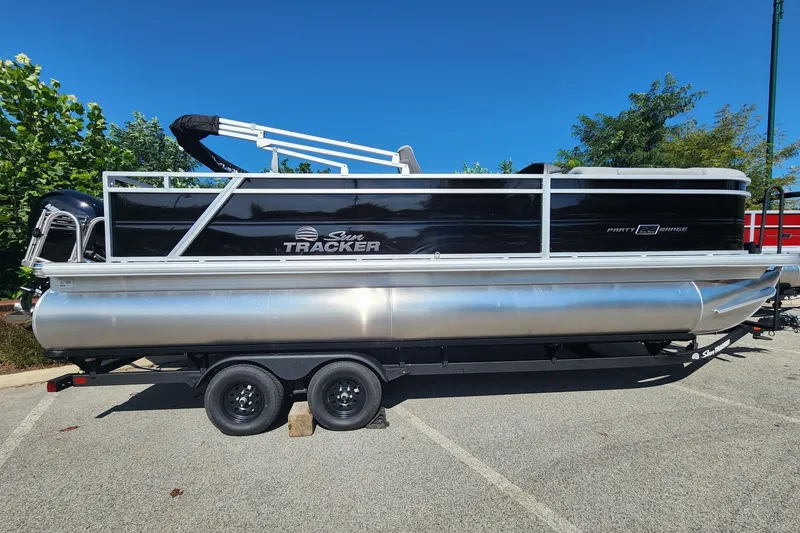 The Image of 2027 Sun Tracker Party Barge 22 RF DLX pontoon boat on trailer, parked outdoors. - 0