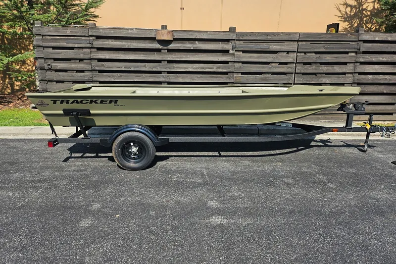 The Image of 2027 Tracker Grizzly 1754 Utility boat on trailer, parked outdoors. - 0