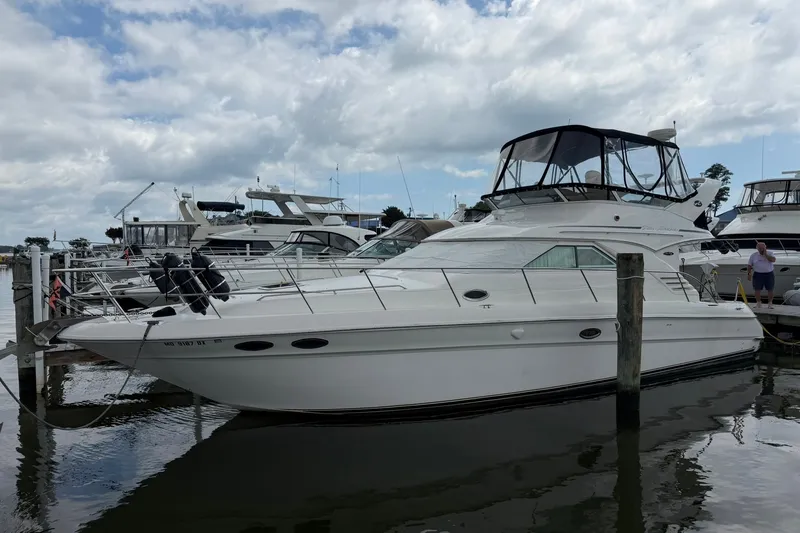 The Image of 2002 Sea Ray Sundancer 400 yacht docked at marina under cloudy sky. - 0