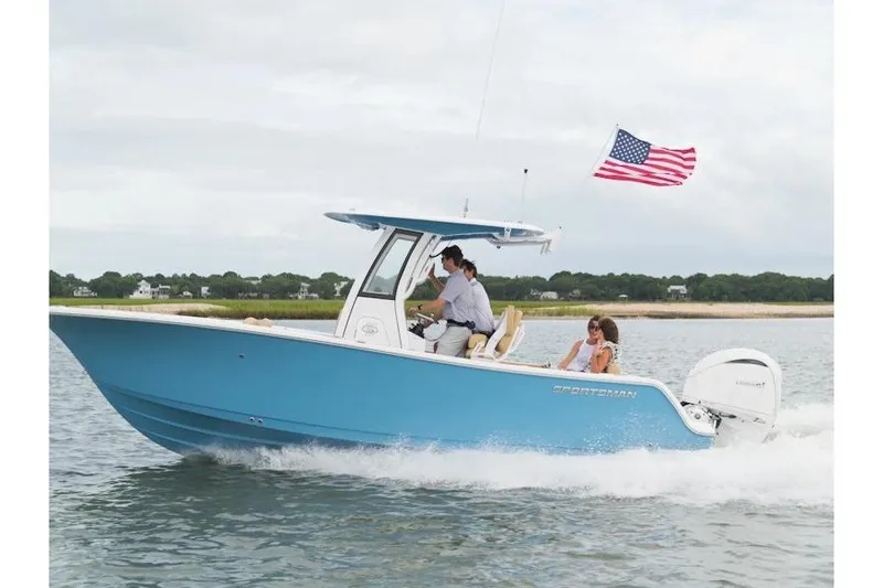 The Image of 2027 Sportsman Open 232 Center Console boat cruising with American flag. - 1
