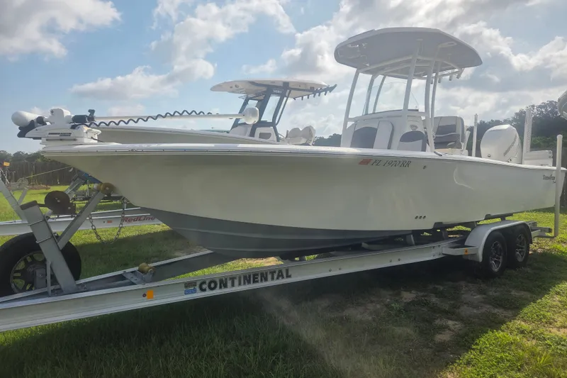 The Image of 2018 Tidewater 2500 Carolina Bay boat on trailer under cloudy sky. - 1