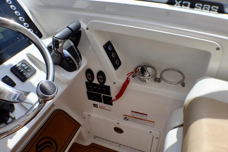 Slide: The Image of 2023 Edgewater 262CX Crossover boat cockpit with steering wheel and controls. - 31