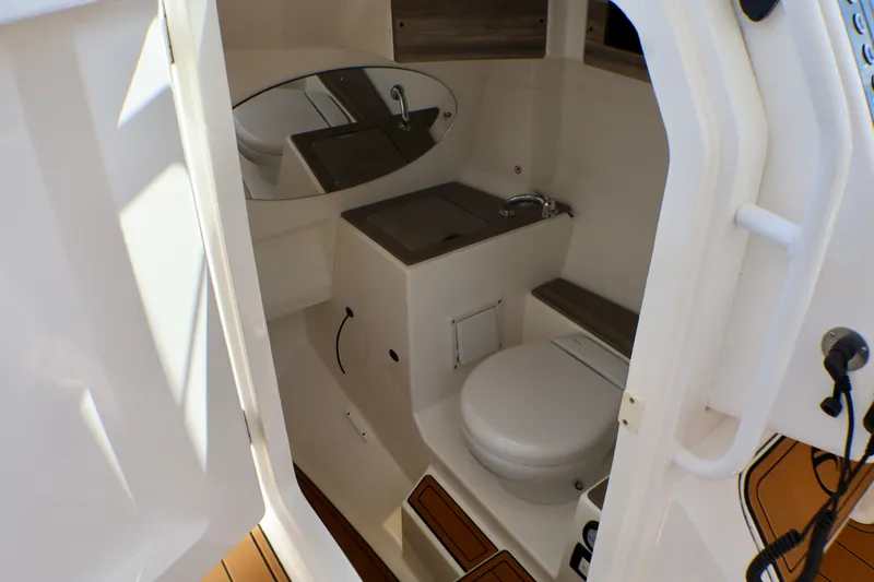 Slide: The Image of 2023 Edgewater 262CX Crossover boat interior with compact bathroom and modern fixtures. - 40